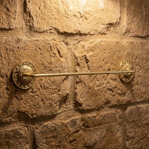 Rustic brass towel bar mounted on stone wall handmade bathroom decor