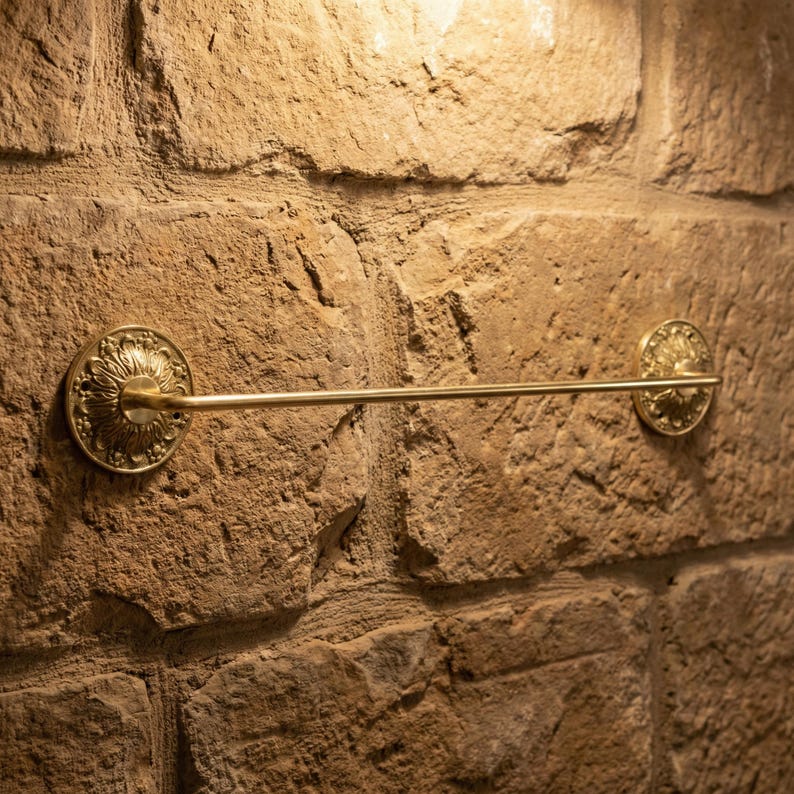 Rustic brass towel bar mounted on stone wall handmade bathroom decor