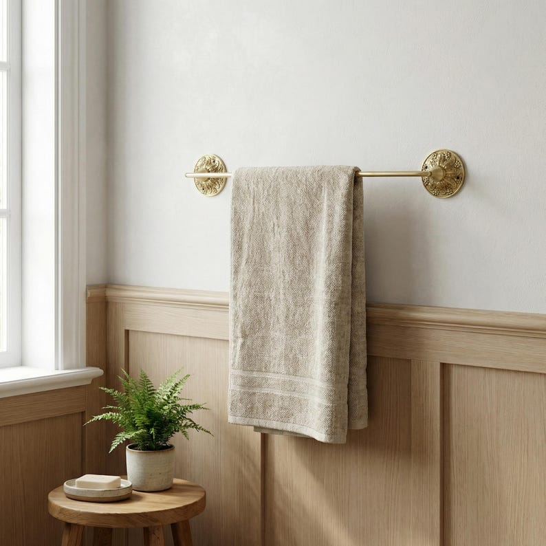 Wall mounted brass towel bar in modern bathroom interior with towel
