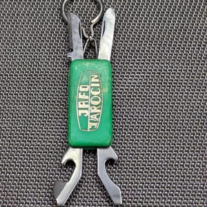 以下が含まれることがあります： 緑色のハンドルとシルバーのツールが付いた、ヴィンテージのマルチツールキーホルダー。ハンドルには白で「JAFO JAROCIN」の文字が入っています。ツールには、ナイフ、栓抜き、その他の小さな器具が含まれます。キー用の小さな金属リングが取り付けられています。