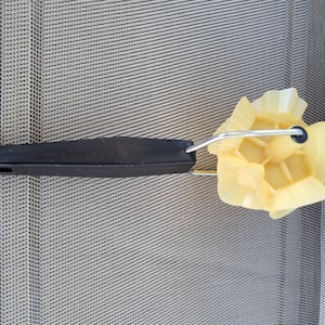 Puede incluir: Un rodillo de pintura negro y amarillo con un marco de metal plateado. El rodillo tiene un mango negro y un cabezal de rodillo amarillo texturizado. El rodillo está diseñado para proyectos de pintura y mejoras para el hogar.