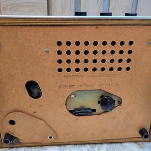 May include: A vintage wooden record player with a brown wood case and a metal control panel. The back of the player has a label that reads "Электрофон "АККОРД" 1.5ГР-82М 127/220В ФАСТ 1137 82."