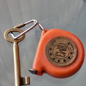 Portachiavi vintage con metro a nastro e vecchia chiave