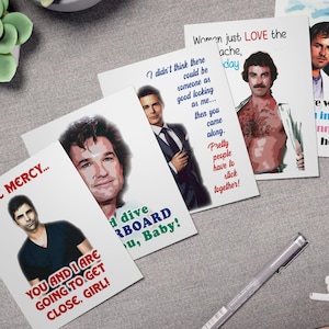 May include: A set of greeting cards with images of actors and quotes. The cards feature text in red, blue, and black. They are arranged on a grey surface with a pen, earbuds, and a succulent plant in a pot.