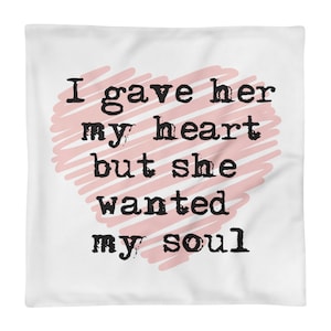 May include: White pillow with a pink heart design and the text "I gave her my heart but she wanted my soul" in black.