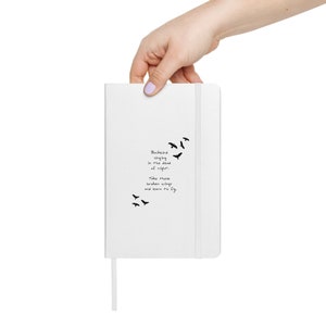 Puede incluir: Un cuaderno blanco con una silueta de pájaro negro y el texto "Blackbird singing in the dead of night. Take these broken wings and learn to fly."