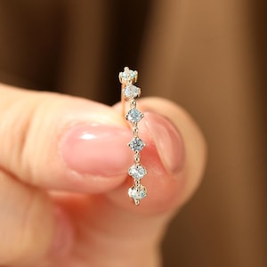 May include: A delicate gold ring with a row of small, clear diamonds set in a curved line.