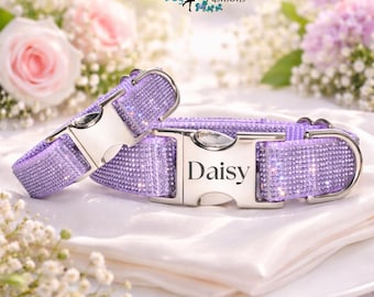 May include: Two lavender dog collars covered in sparkling rhinestones featuring silver-toned metal buckles. The larger buckle is engraved with the name Daisy. The collars are displayed together, showcasing the shimmering texture and metallic hardware.