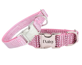 Könnte beinhalten: Zwei rosa Haustierhalsbänder, die mit kleinen, funkelnden Strasssteinen besetzt sind. Jedes Halsband verfügt über eine silberfarbene Metallschnalle zum seitlichen Öffnen. Eine Schnalle ist mit dem Namen Daisy in schwarzer Serifenschrift graviert.