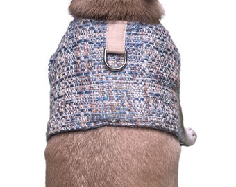 May include: A blue and pink tweed dog harness with a silver metal D-ring.