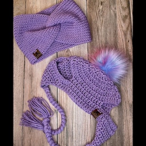 May include: Purple crocheted headband and hat with a fluffy pom pom. The headband has a knot on top and the hat has a long crocheted cord.
