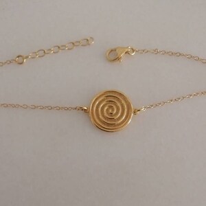 Dainty 14k gold bracelet with an eye-catching Spiral coin disc.