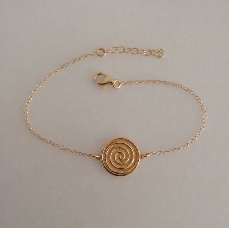 Dainty 14k gold bracelet with an eye-catching Spiral coin disc.