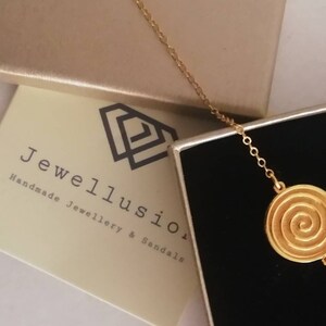 Dainty 14k gold bracelet with an eye-catching Spiral coin disc.