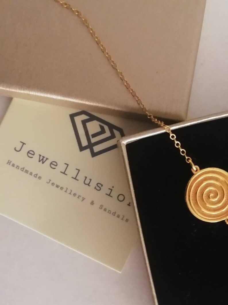 Dainty 14k gold bracelet with an eye-catching Spiral coin disc.