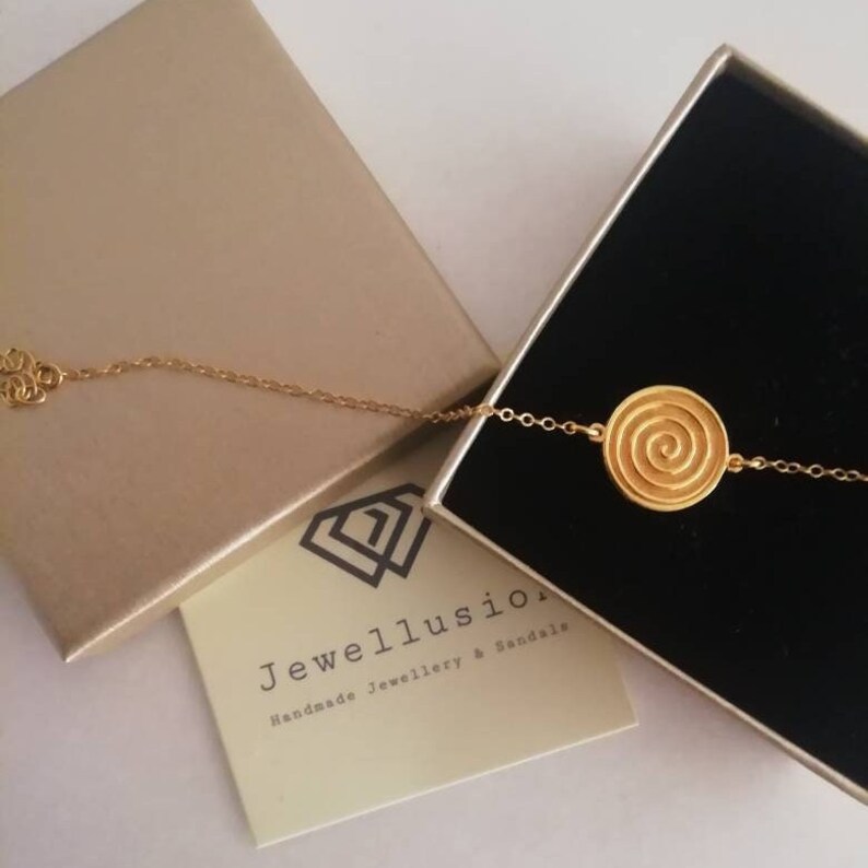 Dainty 14k gold bracelet with an eye-catching Spiral coin disc.