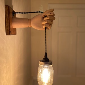 Mannequin hand wall sconce light. Posable hand. Modern funky steampunk design style. Unique and creative.