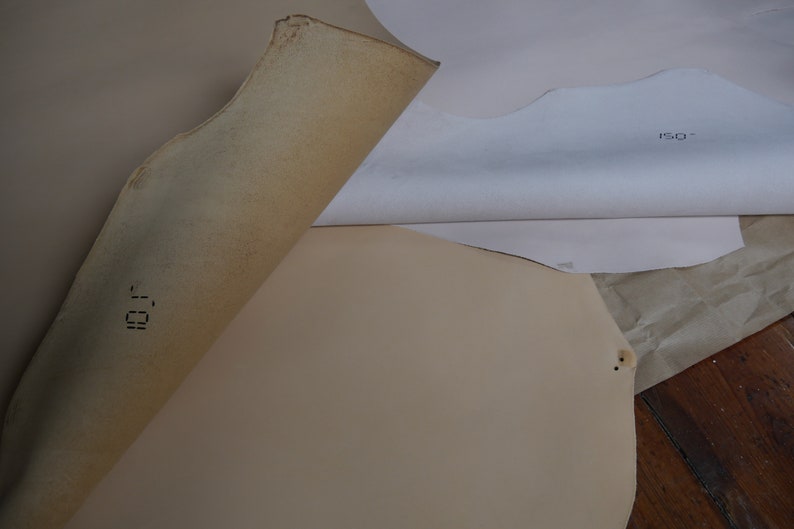 May include: Close-up of two pieces of beige leather with the text "101" and "ISO" printed on them.