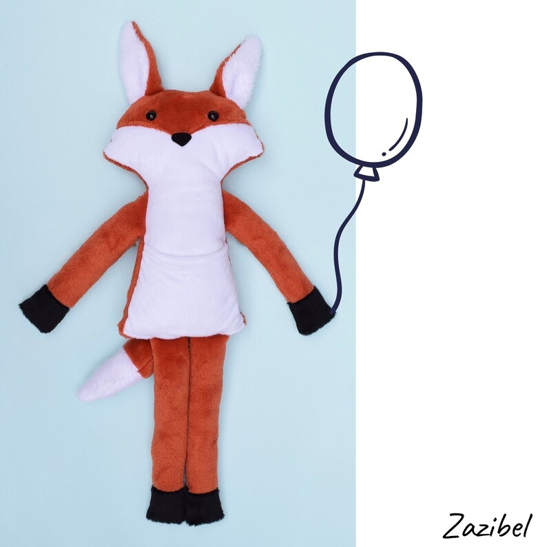 May include: A plush fox toy with a white belly and black feet, lying on a light blue background. A black and white balloon is drawn in the background.