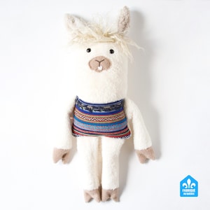 May include: A plush white llama doll with a colorful patterned sweater. The llama has tan ears, hooves, and a small mouth. The doll has a fluffy head of hair and a small tag in the bottom right corner.