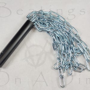 Puede incluir: Un mango negro est&aacute; unido a una serie de cadenas de metal plateado. Las cadenas est&aacute;n conectadas entre s&iacute;, formando una hebra larga y flexible. El mango tiene un peque&ntilde;o lazo de metal en el extremo.