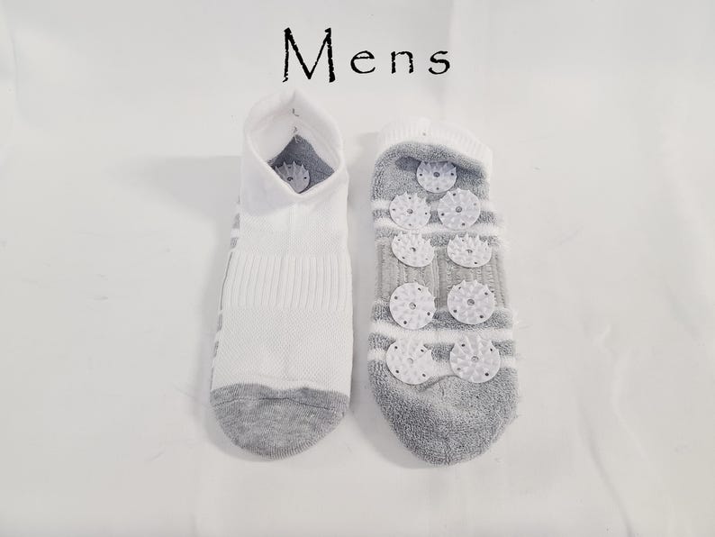 Pu&ograve; includere: Un paio di calzini alla caviglia con la scritta Mens stampata sopra. Un calzino &egrave; bianco con punta e tallone grigi, mentre l'altro &egrave; grigio con strisce bianche e presenta diversi piccoli dischi di plastica bianca testurizzati sulla suola.