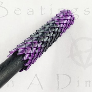 May include: A black and purple dragon scale patterned grip for a walking stick or cane.