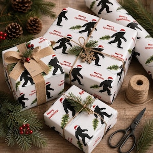 May include: White wrapping paper featuring a repeating pattern of black silhouettes of a creature wearing a red Santa hat and carrying a small green pine tree, with the red text Merry Squatchmas. Includes gift boxes, twine, and a tag.