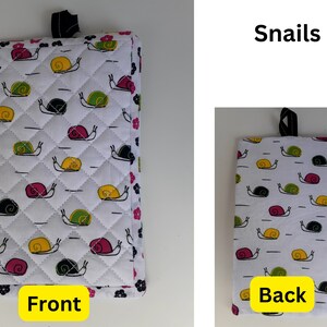 May include: A white quilted hot pad with a black hanging loop. The front of the hot pad features a repeating pattern of colorful snails. The back of the hot pad has the same pattern. The words "Front" and "Back" are printed on the bottom of the hot pad.