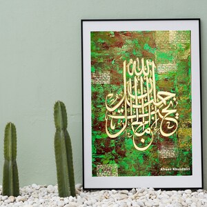Puede incluir: Una impresión enmarcada de caligrafía islámica en oro sobre un fondo texturizado verde y marrón. El texto dice "Allah" y "Muhammad" en árabe. El nombre del artista, "Afreen Khundmiri", está impreso en la esquina inferior derecha.