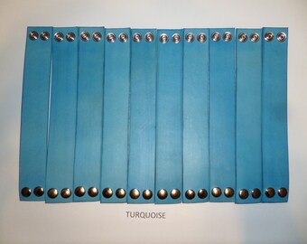 May include: Twelve turquoise leather bracelets with silver metal snaps. TURQUOISE is written below the bracelets.