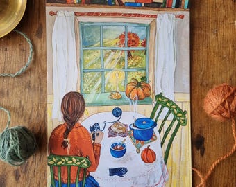 Op de afbeelding: Een aquarel schilderij van een vrouw die aan een tafel bij een raam zit te breien. Het raam kijkt uit op een veld met een boom in de verte. Er staat een kom soep, een brood en een pompoen op de tafel. De tekst "Lorna" staat in de rechter benedenhoek van het schilderij.