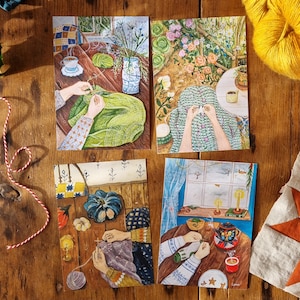 May include: Four illustrated postcards showing scenes of knitting and crafting. One depicts a person knitting a green sweater, another shows knitting in a garden, and two others show knitting with seasonal elements. The cards are arranged on a wooden surface.