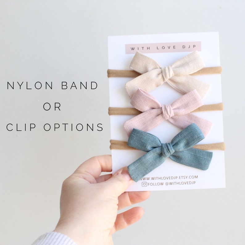 Puede incluir: Conjunto de cuatro lazos para el pelo en beige, rosa, azul claro y verde azulado. Los lazos est&aacute;n hechos de tela y se sujetan a una banda de nylon o a una pinza. El texto "WITH LOVE DJP" est&aacute; impreso en la tarjeta. El texto "WWW.WITHLOVEDJP.ETSY.COM" y "FOLLOW @WITHLOVEDJP" est&aacute; impreso en la tarjeta.