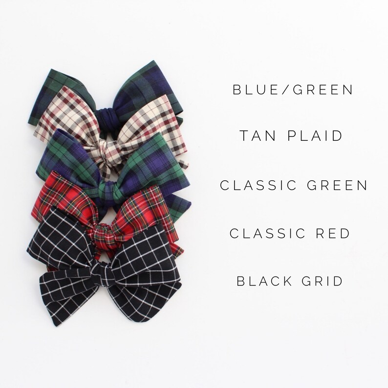 May include: Five different plaid hair bows in various colors, including blue, green, tan, red, and black. The bows are arranged in a stack, with the blue and green bow on top and the black bow on the bottom. The text "BLUE/GREEN", "TAN PLAID", "CLASSIC GREEN", "CLASSIC RED", and "BLACK GRID" is written below each bow.