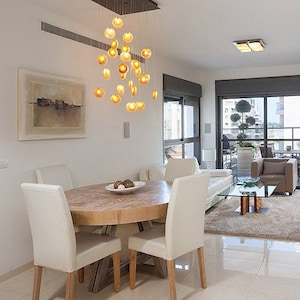 Sophisticate Reef Chandelier with Amber pendants over dining room table on rectangular canopy