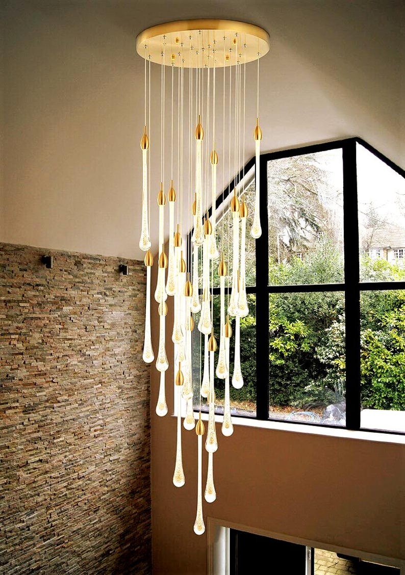 Unique staggered Ferraro Chandelier on Bronze round canopy in Foyer. High Ceiling Design Idea