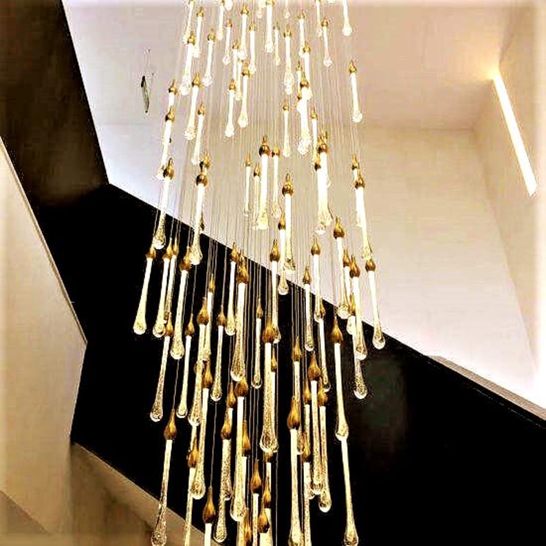 Bespoke clustered Ferraro Chandelier by staircase. High Ceiling Design Idea