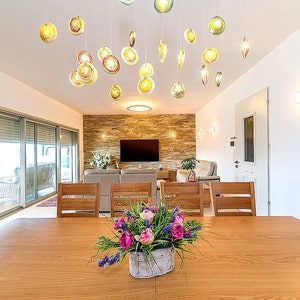 Modern multi color Reef chandelier over dining room table on rectangular canopy