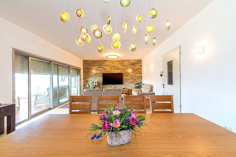 Modern multi color Reef chandelier over dining room table on rectangular canopy