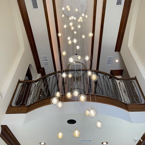 Foyer-two-story-chandelier-REFLECTION- Clear-glass-pendant-lighting, contemporary-modern-blown-glass-lighting, custom-long-staircase-lights.