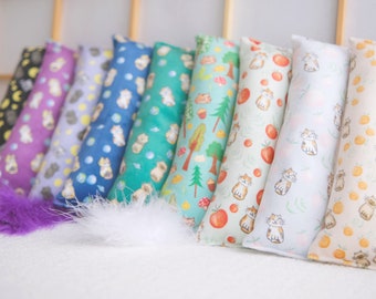 May include: A set of ten colorful catnip-filled toys for cats. The toys are made of fabric and have different patterns, including cats, trees, and fruit. The toys are arranged in a row on a white surface.