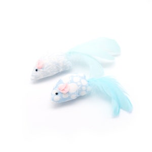 May include: Two blue and white cat toys shaped like mice with pink ears and long blue feather tails.