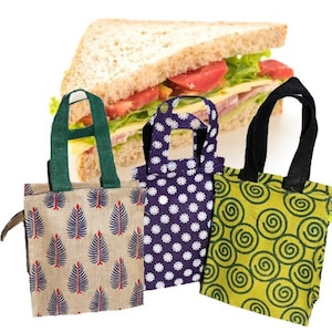May include: Three reusable lunch bags made of jute fabric with different patterns. The bags have a green, black, and purple color scheme. The bags are perfect for carrying a sandwich or other snacks.