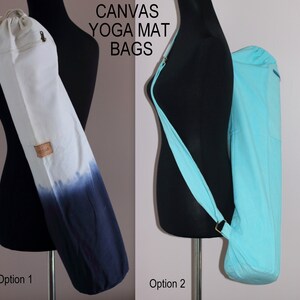 May include: Two canvas yoga mat bags. The bag on the left is white with a blue ombre design. The bag on the right is a solid light blue. Both bags have a long strap for carrying over the shoulder.