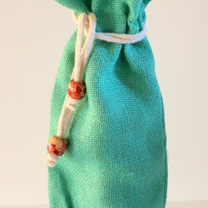 May include: Plain green fabric wine bottle bag with a white drawstring and wooden beads. (no sheer collar)