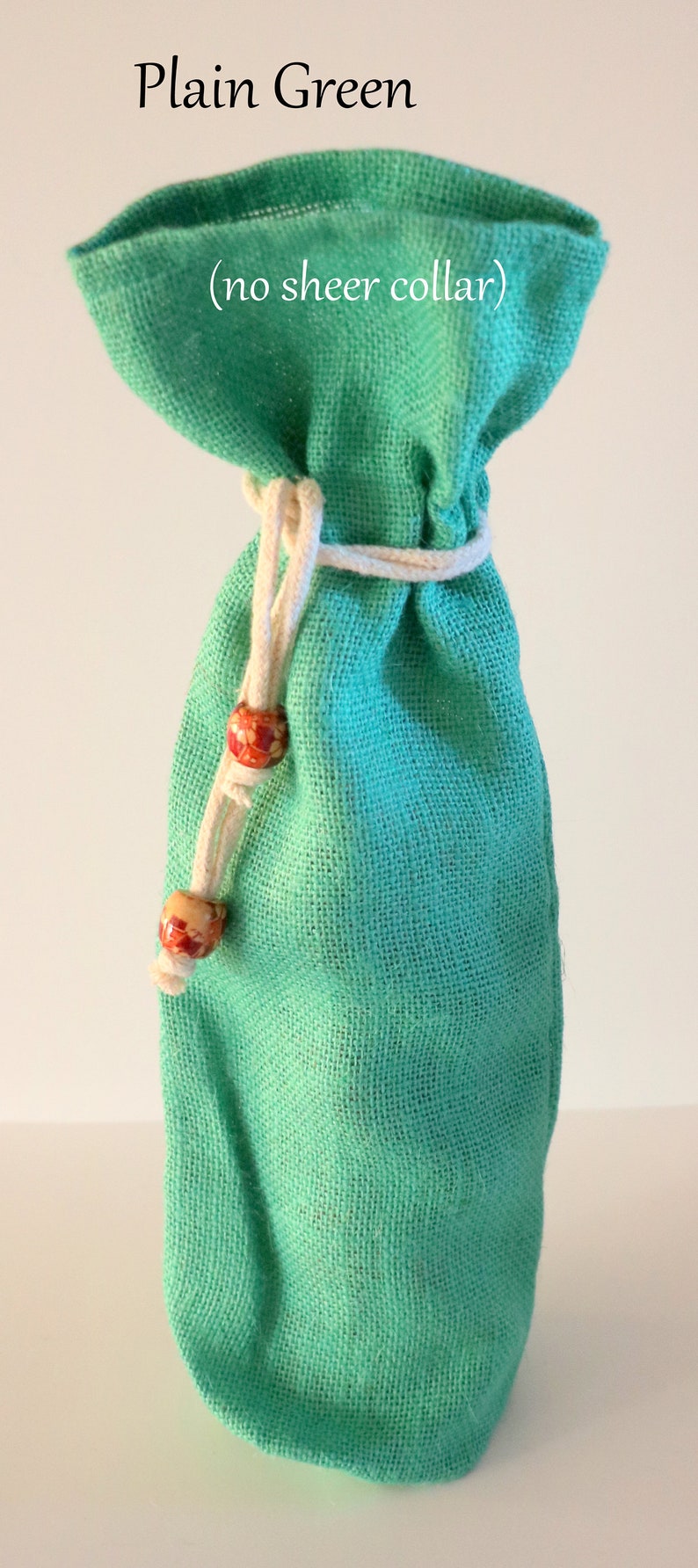 May include: Plain green fabric wine bottle bag with a white drawstring and wooden beads. (no sheer collar)