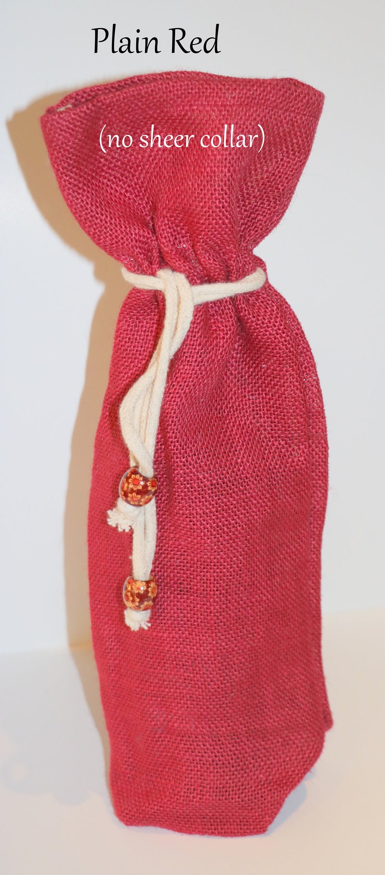 May include: Plain red burlap gift bag with a white drawstring and wooden beads. The bag has the text "(no sheer collar)" printed on it.