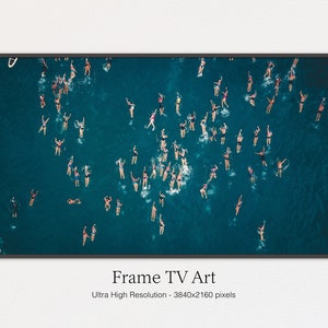 Puede incluir: Una vista aérea de un grupo de personas nadando en un océano azul turquesa. Las personas están dispersas por el agua, algunas nadan de espaldas, otras nadan boca abajo y otras simplemente flotan. El agua es clara y el cielo es azul.