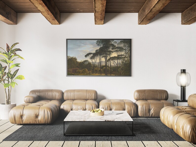 Pode incluir: Um sof&aacute; seccional de couro marrom com uma mesa de caf&eacute; preta na frente. Uma pintura de paisagem emoldurada est&aacute; pendurada na parede atr&aacute;s do sof&aacute;. Uma planta em vaso est&aacute; no canto da sala.